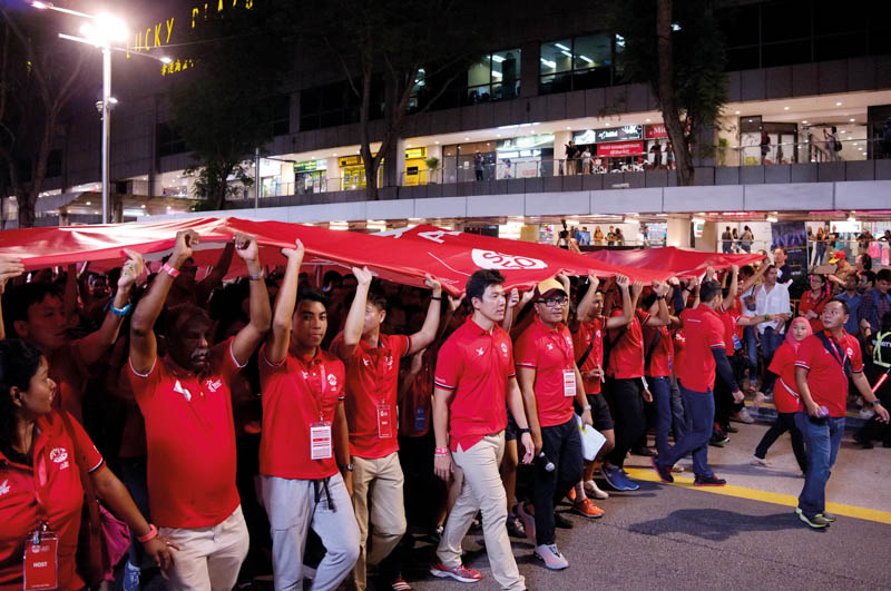Athletes and officials carried the Team Singapore flag down Orchard Road at the three-month countdown ceremony in March 2015.