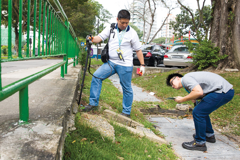 Mr Decry and colleague Azriel Lai conduct a routine check on a drain in Whampoa.