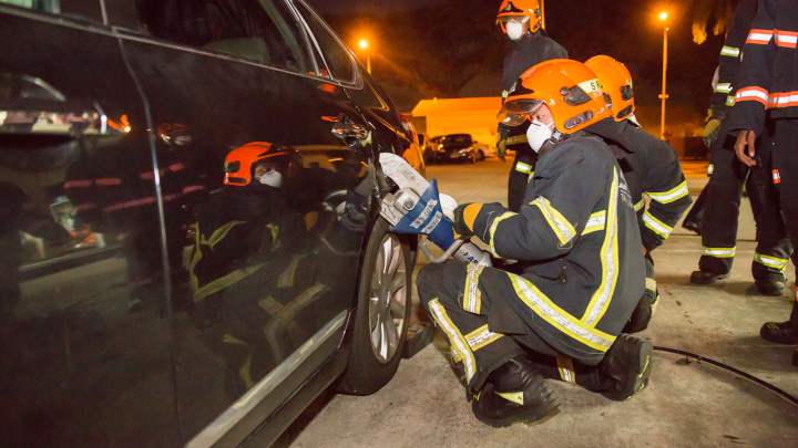 Trainee SCDF volunteer firefighters prying open a locked car door